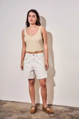 Bermuda de denim color blanco con costuras en contraste, tiro medio y ruedo desflecado.