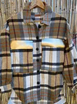 Sobre camisa a cuadros con bolsillos frontales con solapa en cuero.