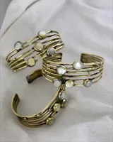 Pulsera rígida de bronce con apliques de nácar. Se ajusta a presión.