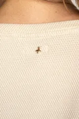 Sweater color crema con una franja horizontal verde en el pecho, de corte oversize y mangas largas.