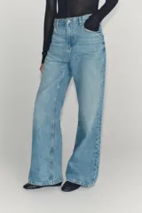 Jeans de tiro bajo y pernera flare, confeccionados en denim de algodón con efecto lavado claro. Presenta diseño clásico de cinco bolsillos, trabillas para cinturón y cierre frontal con cremallera y botón metálico.