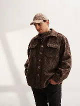 Camisa leñadora de lana color marrón oscuro, con cuello clásico, cierre frontal con botones, bolsillos frontales con solapa y mangas largas con puños abotonados.