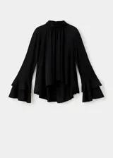 Blusa negra de cuello alto con cierre de botones, diseño recto y mangas largas acampanadas con volantes en los puños. Confeccionada en tejido fluido.