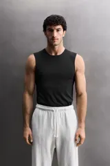 Musculosa deportiva de Zara Athleticz, confeccionada en tejido técnico elástico y transpirable. Presenta cuello redondo, diseño sin mangas y costuras planas termoselladas para mayor confort. Incluye detalle de logo en el dobladillo inferior.