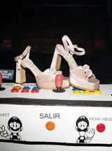 Sandalias de tacón alto Mutma modelo Ñoma, confeccionadas en terciopelo color beige, con plataforma, tira ajustable al tobillo y detalle de doble lazo en la punta.