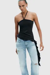 Top negro de cuello halter con lazada, escote recto y hombros descubiertos. Presenta un volante asimétrico en el lateral.
