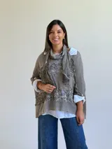 Sweater de punto color visón con diseño superpuesto, que incluye una bufanda integrada y detalles de encaje floral en el frente. Presenta mangas tres cuartos con puños abotonados y un corte holgado.