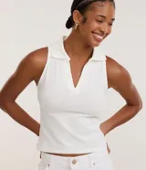 Blusa sin mangas de color blanco, con cuello polo y escote en V, confeccionada en algodón con elastano.