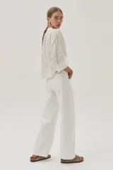 Blusa blanca de algodón con hilos metalizados, cuello mao y escote en V.