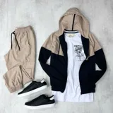 Campera de nylon anti-lluvia con capucha, combinación de colores beige y negro.