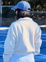 Gorra tipo baseball de color azul con efecto lavado, con bordado frontal de un escudo con una piña en el centro.