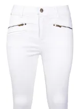 Jeans skinny de tiro medio color blanco, con cierre frontal, bolsillos delanteros con cierre y ruedo desflecado.