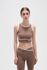 Top deportivo sin mangas, color camel, con cuello redondo y detalles de ribete en color blanco en el cuello y bajo el busto.