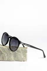 Lentes de sol unisex con montura redonda de carey y lentes polarizadas grises.