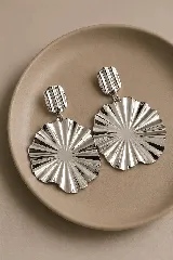 Caravanas colgantes de diseño circular con acabado plisado y brillante, compuestas por una pieza superior pequeña y una pieza inferior grande de forma ondulada.