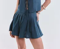 Short pollera plisado con cierre trasero.