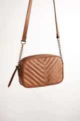 Cartera bandolera negra con diseño capitoneado en forma de V, correa de cuero y cadena plateada, cierre metálico y doble bolsillo interior.