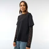 Camiseta negra de algodón con diseño 2 en 1, que combina un cuerpo de remera de manga corta con mangas largas integradas de encaje floral.