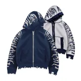 Hoodie con cierre frontal, tejido en algodón con diseño reversible. Presenta detalles de roturas intencionales en puños, ruedo y costuras, con estampado gráfico en mangas y capucha.