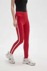 Calza deportiva de tiro alto, color rojo, confeccionada en poliamida con ajuste al cuerpo.