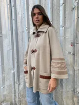 Saco capa color beige, tejido en lana con detalles de trenzas en cuello y puños.