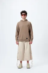 Bermuda color beige de corte ancho, con bolsillos cargo laterales y tiras ajustables en el ruedo.