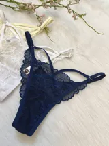 Pack de tres tangas de encaje con tiras regulables, colores variados: amarillo, blanco y azul marino.