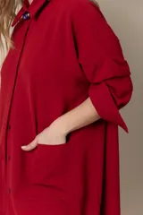 Camisa larga color rojo, de seda poliéster, con cuello clásico, cierre frontal con botones, mangas largas y bolsillos grandes.