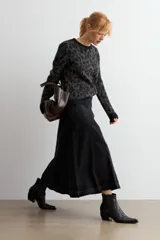 Sweater de punto con diseño animal print en tonos gris oscuro y negro, de cuello redondo y manga larga.