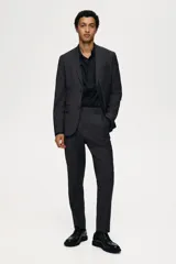 Blazer gris oscuro de corte slim fit, con solapas de muesca finas, ojal decorativo, botonadura sencilla, bolsillo superior insertado, bolsillos delanteros con solapa, dos bolsillos interiores, botones decorativos en los puños y abertura doble atrás.