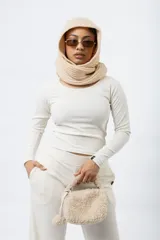 Remera de manga larga color blanco hueso, con cuello redondo y tejido acanalado.