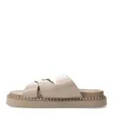 Sandalias planas Miss Carol modelo Zelv, color beige, con tiras anchas decoradas con hebillas metálicas doradas y tachas, sobre suela de plataforma baja con costuras visibles.