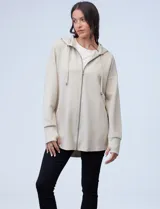 Campera color beige de modal, con cierre metálico central, capucha con cordón de ajuste y tajos laterales.