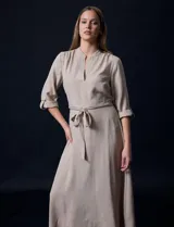 Vestido maxi color beige, con cuello mao, mangas 3/4 con presilla y lazo en la cintura.