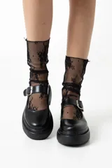 Mocasín negro de cuero con hebilla plateada y suela track.