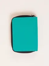 Billetera de nylon color verde esmeralda con cierre perimetral y parche de goma negro con logo grabado en el frente.