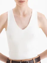 Top negro de tejido frío, ajustado al cuerpo y largo por debajo de la cintura.