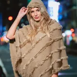 Poncho color habano con cuello alto y flecos diagonales. Tejido de acrílico.