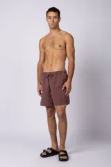 Short de baño de corte clásico con cintura elástica y cordón ajustable. Presenta un acabado efecto lavado vintage, bolsillos laterales y un pequeño logo bordado en la parte inferior.