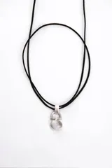 Gargantilla con cordón doble de cuero sintético negro y dije circular plateado con piedra blanca traslúcida.