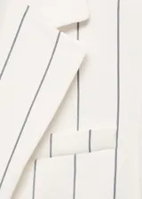 Blazer de corte recto con estampado de rayas verticales, cuello con solapas de muesca, hombros estructurados y cierre frontal con botones. Cuenta con bolsillo de ribete en el pecho y dos bolsillos con solapa en la parte frontal.
