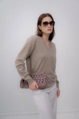Sweater color beige de cashmere con escote en V y mangas largas.