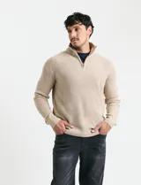 Sweater de punto inglés color verde, con cuello alto y cierre frontal parcial metálico. Diseño de manga larga con puños y ruedo acanalados.