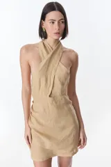 Vestido corto color beige de lino, con cuello halter cruzado y espalda descubierta.