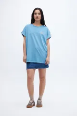 Musculosa de algodón lavado con textura extra suave, teñida en prenda en tono verde. Presenta un calce oversize, mangas diferenciadas, arte estampado en el pecho y un corte en la espalda.