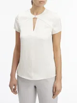Blusa blanca de satén con cuello redondo con abertura en forma de V y mangas cortas.