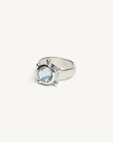 Anillo de plata 925 con banda chata, protagonizado por una piedra facetada central de topacio y detalles de esferas decorativas.