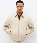 Campera estilo Harrington de corte bomber, confeccionada en material con acabado de gamuza sintética. Presenta cuello con solapa, cierre frontal completo, mangas largas y bolsillos laterales con cierre.