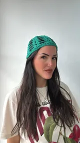 Gorro de crochet color verde esmeralda con diseño calado.