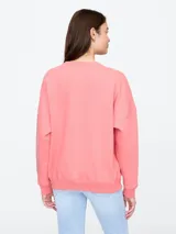 Buzo de cuello redondo en color gris oscuro, con diseño de hombros caídos y puños acanalados. Presenta un pequeño bordado en el pecho con el logo de la marca y dos raquetas de tenis cruzadas.